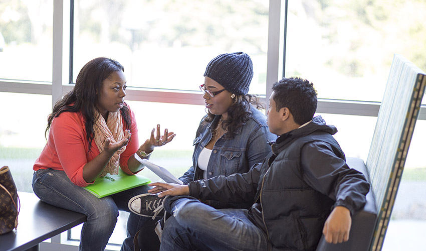 Metro student Kayla Jackson discusses a math problem with Metro students Ivanna Carroll and Henry Eik.